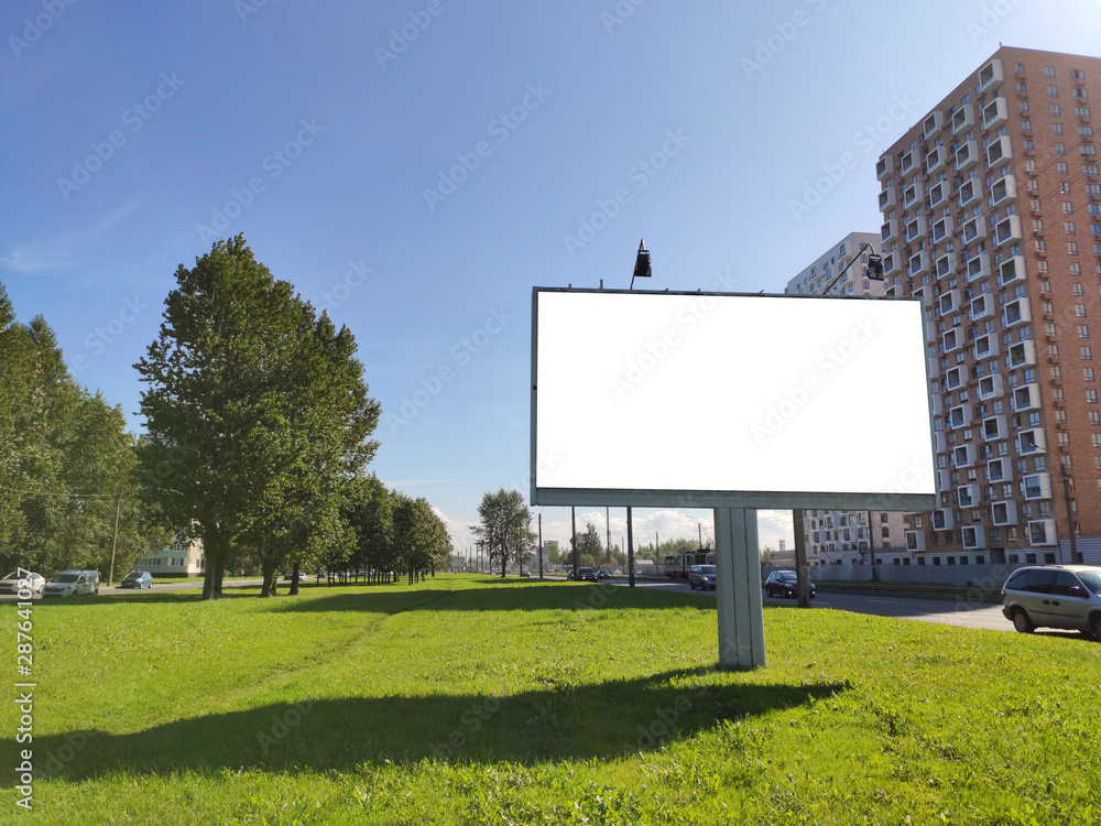 large billboard advertising in the city on a green lawn and against a blue sky large billboard advertising in the city on a green lawn and against a blue sky