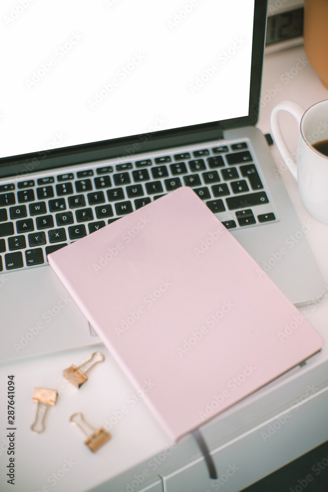 Laptop and notebook on a white table