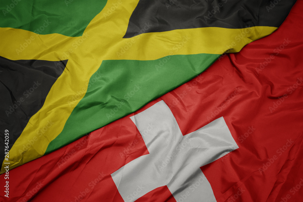 waving colorful flag of switzerland and national flag of jamaica. waving colorful flag of switzerland and national flag of jamaica.