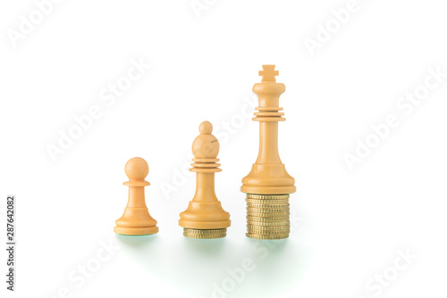 Conceptual photo with chess pieces and coins showing the concept of social and economic reality.