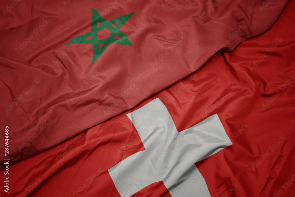 waving colorful flag of switzerland and national flag of morocco. waving colorful flag of switzerland and national flag of morocco.