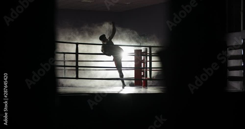Dedicated athlete doing a shadow fight on boxing ring, practicing muay thai martial art, preparing for a fight - sports, martial arts concept 4k footage