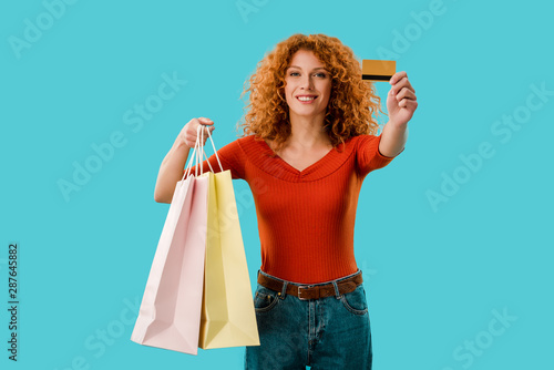 happy girl holding shopping bags and credit card, Isolated On blue