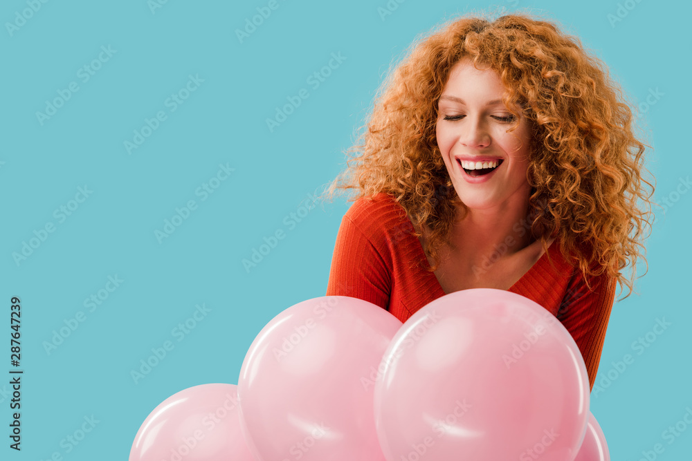 smiling redhead girl with pink balloons isolated on blue smiling redhead girl with pink balloons isolated on blue