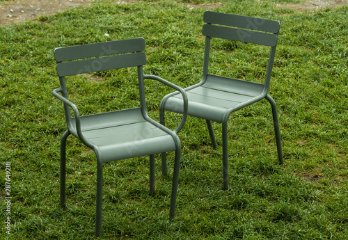 metal street chairs on green grass in the summer during the daytime