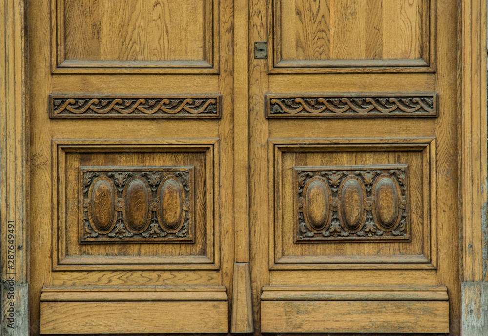 beautiful vintage solid wood door with carved patterns and a gold vintage handle
