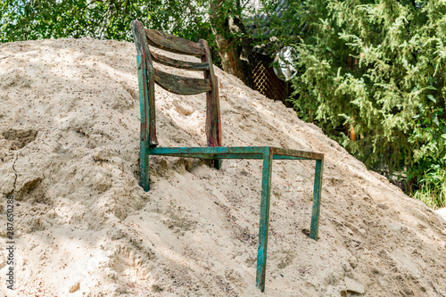 Old broken chair in a pile of sand © Сергей Старостов