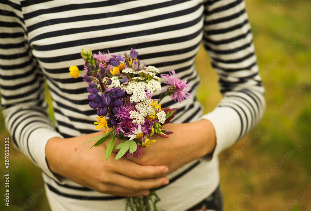 girl holding a bouquet of wild flowers.