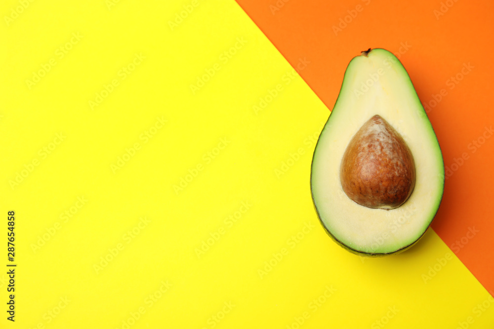Cut fresh ripe avocado on color background, top view with space for text
