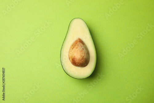 Fotografering Cut fresh ripe avocado on green background, top view