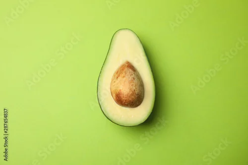 Obraz połówka dojrzałego avocado na zielonym tle