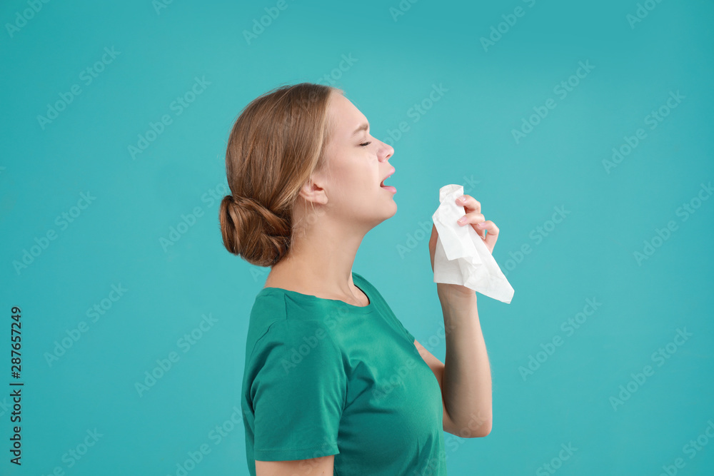 Young woman suffering from allergy on turquoise background Young woman suffering from allergy on turquoise background