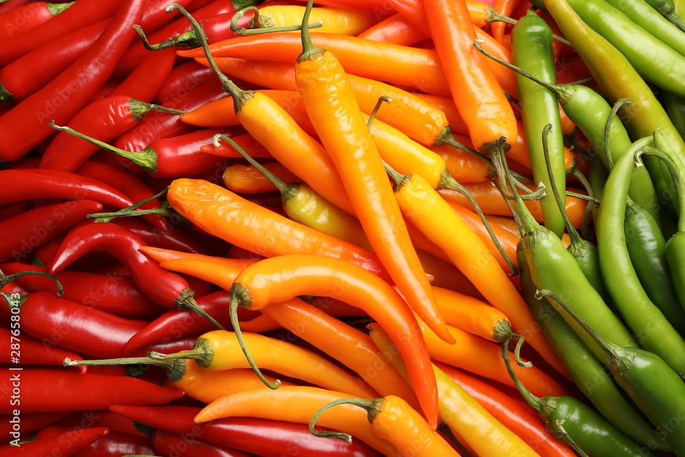 Different ripe chili peppers as background, top view Different ripe chili peppers as background, top view