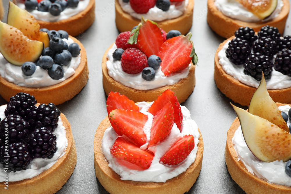 Many different berry tarts on table. Delicious pastries Many different berry tarts on table. Delicious pastries