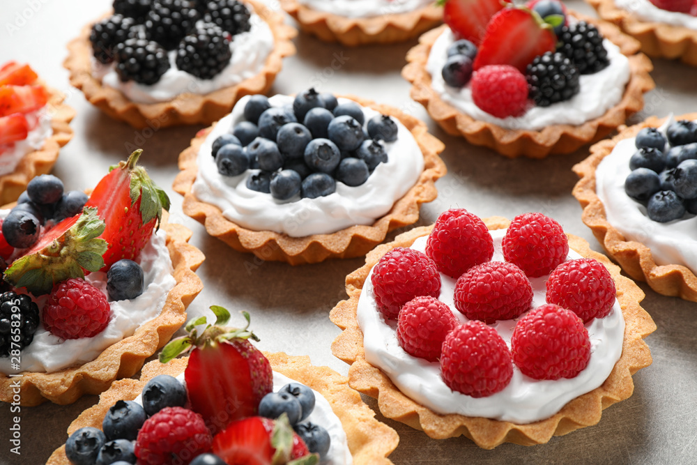 Many different berry tarts on table. Delicious pastries Many different berry tarts on table. Delicious pastries