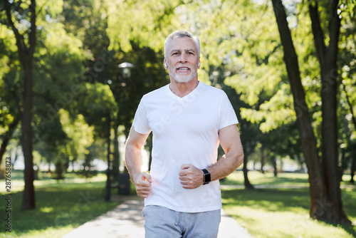 Fototapeta Naklejka Na Ścianę i Meble -  Healthcare concept. Senior caucasian man jogging in a park