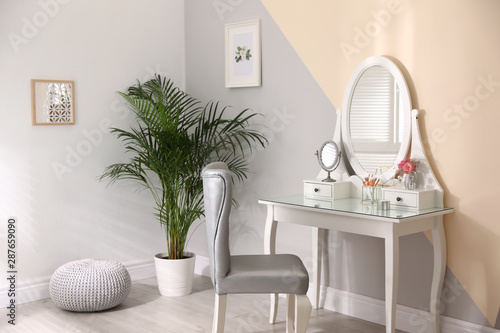 Stylish room interior with modern dressing table and elegant chair