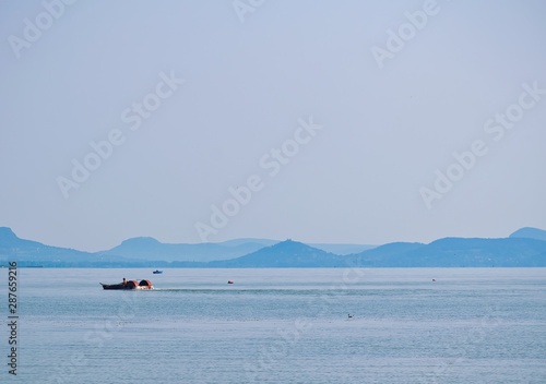 Traditional lake eed cutter in hungary on Balaton lake during summer time. Empty background. photo