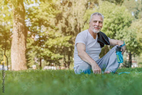 Senior caucasian man relaxing in park after exercise