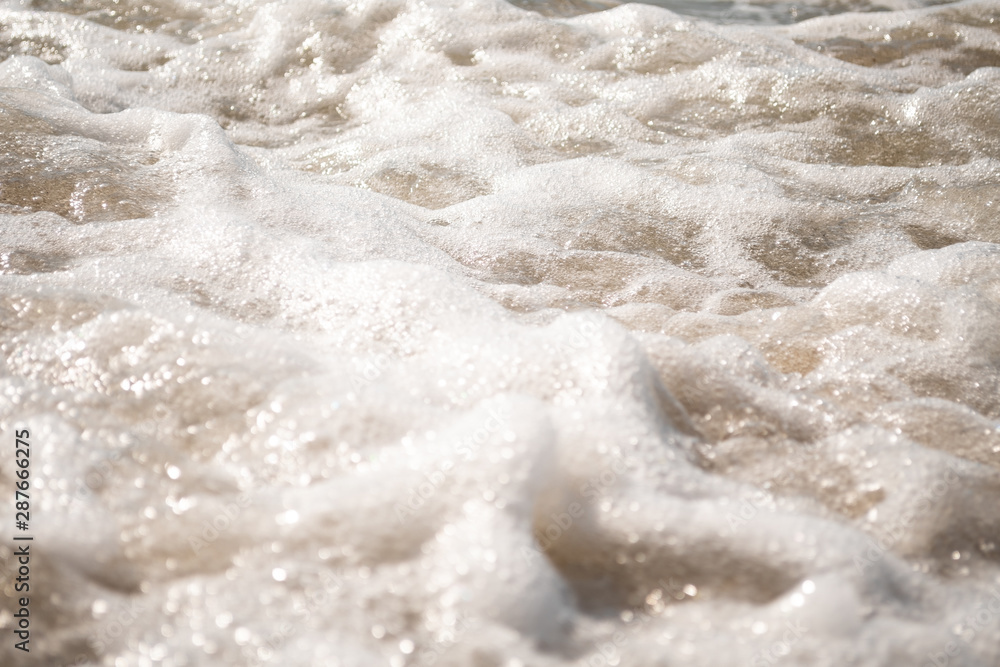 Close-up of Foamy Water Over Sand