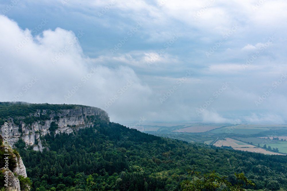 Clouds going through the mountain peak in Madara, Bulgaria Clouds going through the mountain peak in Madara, Bulgaria