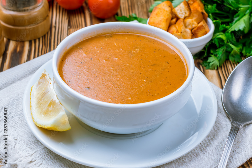 Lentil soup with lemon on wooden table. Turkish cuisine Lentil soup with lemon on wooden table. Turkish cuisine