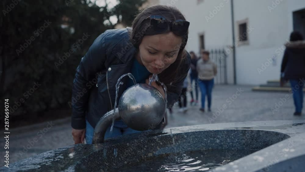 young girl drinks from a drinking fountain young girl drinks from a drinking fountain