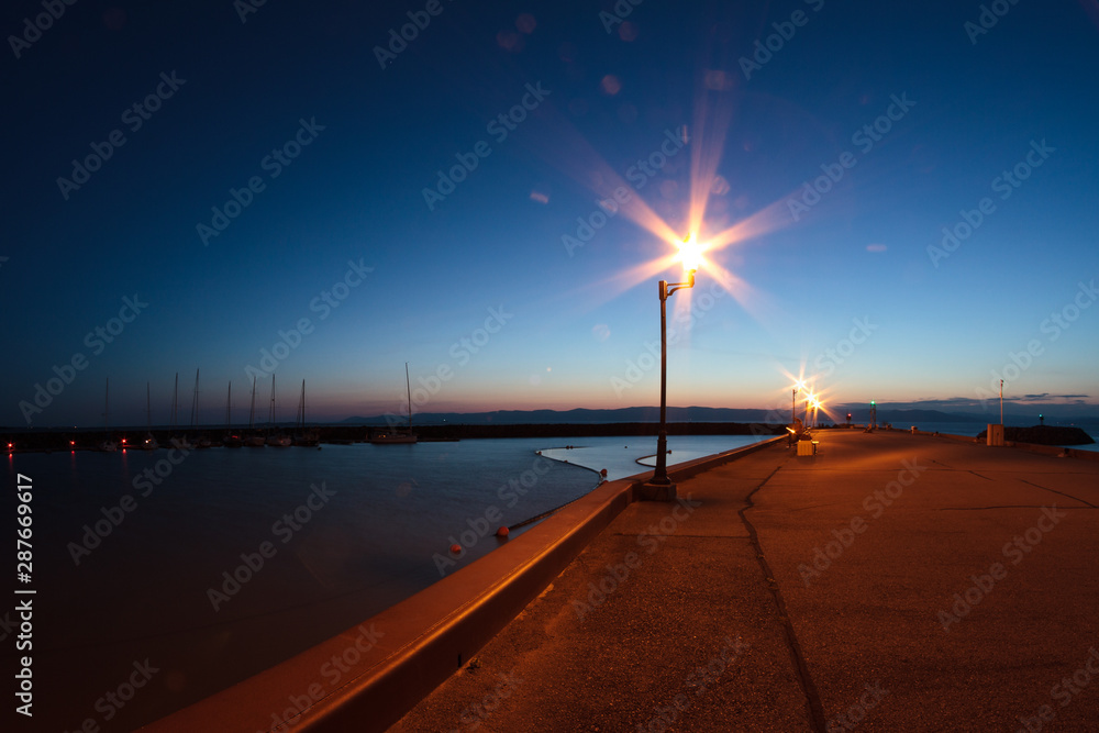 Harbor and light pole at marina dock at night, summer. Wide view. St-Jean-Port-Joli, Qc. Canada. Lampadaire au Quai de St Jean Port Joli, Québec de nuit