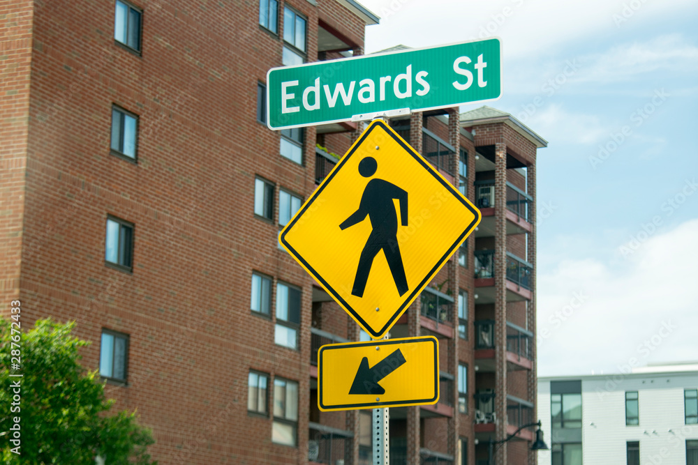 A city street sign CROSSWALK IS HERE, helping pedestrians and drivers