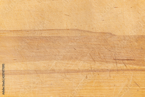 Old scratched wooden cutting board texture background.