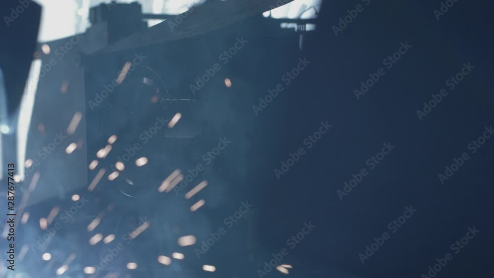 MIG Continuous wire feeding unit, with welding sparks in foreground. MIG Continuous wire feeding unit, with welding sparks in foreground.