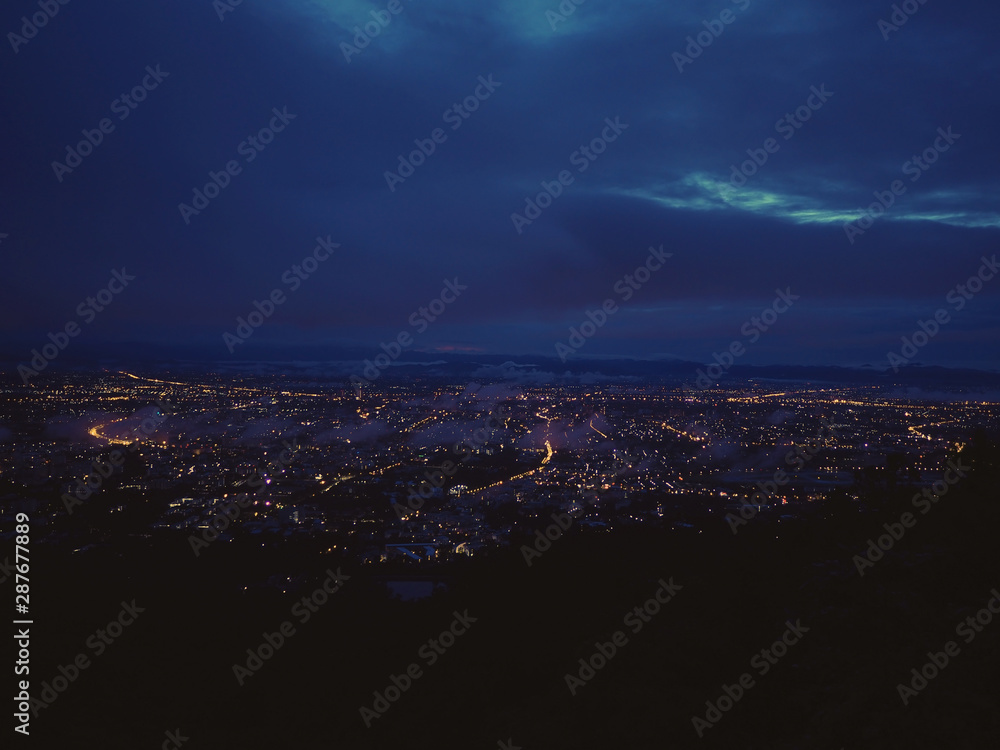 Fototapeta premium Aerial view of night city light with bokeh from the view point of mountain