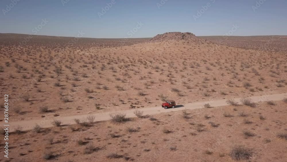 Aerial view of vehicle driving on desert dirt road, California Aerial view of vehicle driving on desert dirt road, California