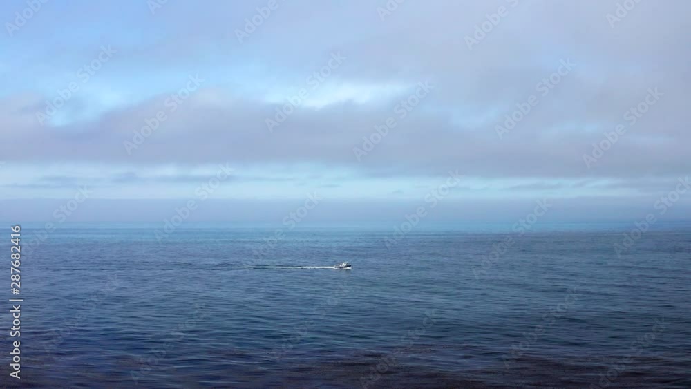 Aerial view of boat traveling open ocean, wide shot Aerial view of boat traveling open ocean, wide shot