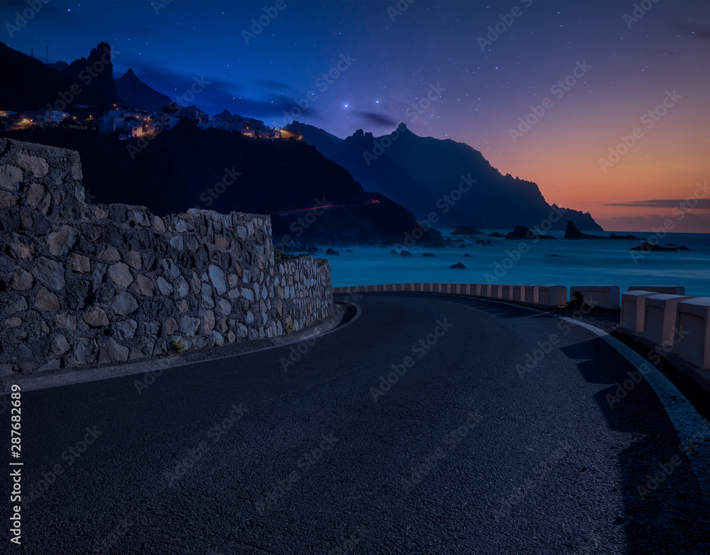 Road over the ocean at night.