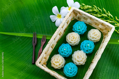 Traditional Thai dessert flower shape stuff with crush soybean and taro (Thai name kanom Chor phaka) in bamboo basket on bana leaf. photo