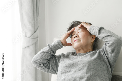 Tableau sur toile Asian senior woman having headache at home, health care concept.