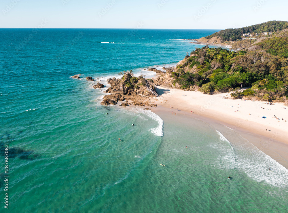 Aerial view of the pass in Byron bay during a nice afternoon with many surfers, swimmers and surfers.