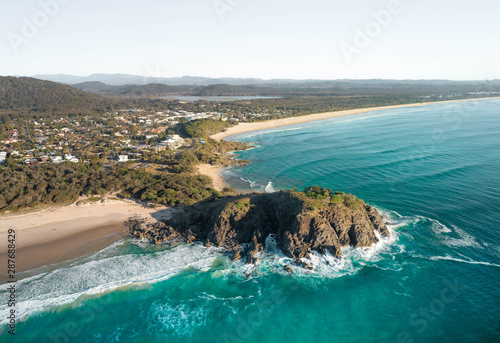 Sunrise aerial of Cabarita Headland in New South Wales, Australia. Beautiful sunrise light with waves on white sand beach. One of many favourite backpacker stop on road trip holiday.