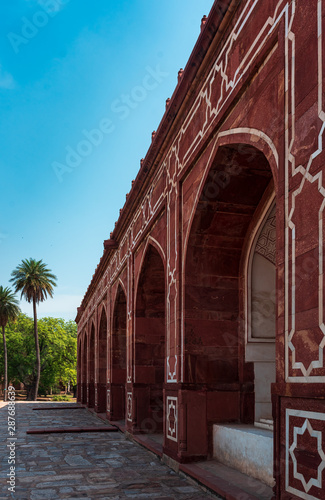Row of arches at the Humayun s Tomb with Blue sky and green trees background.