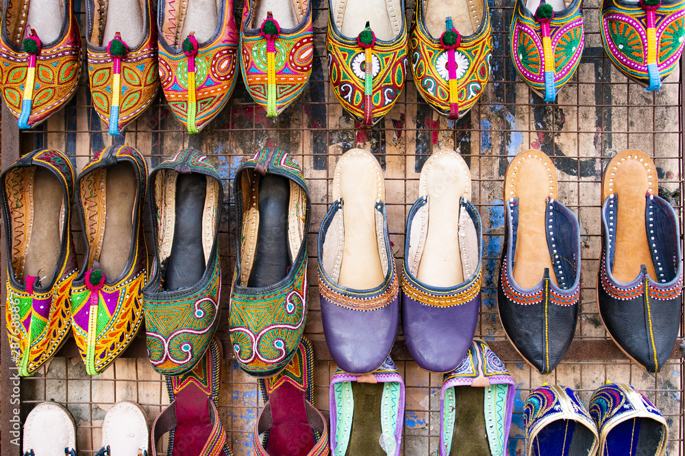 Beautiful and colorful traditional Rajasthani shoes hang in a shop in Jaipur. Mojari or Khussa or Saleem Shahi's is a style of handcrafted footwear produced in Rajasthan, India