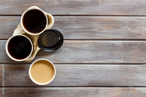 Coffee to take away on wooden background top view. Translation of the Russian text on the lid is Caution: contents hot