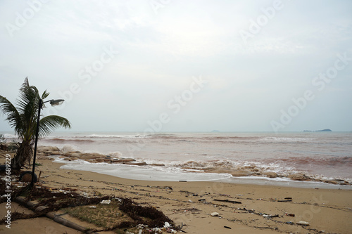 Heavy windy storm by monsoon with the red color sea water beach in Thailand