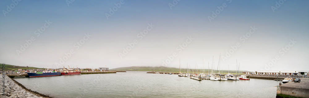 Fototapeta premium Ships in the Dingle harbour on foggy day.