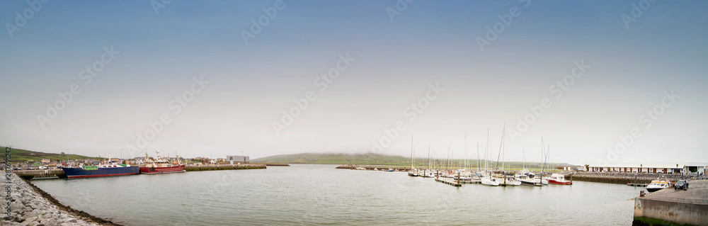 Ships in the Dingle harbour on foggy day.