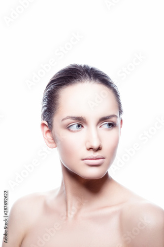 Beauty face of fashion model woman copy space. Brunette hair style, perfect skin, nude natural makeup, blue eyes. White background. Isolated