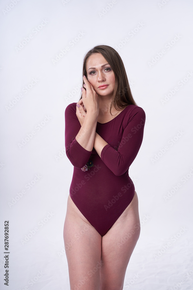 Beautiful girl in swimsuit posing against grey white background. Well-groomed skin. Sexy attire . Beautiful girl in swimsuit posing against grey white background. Well-groomed skin. Sexy attire .