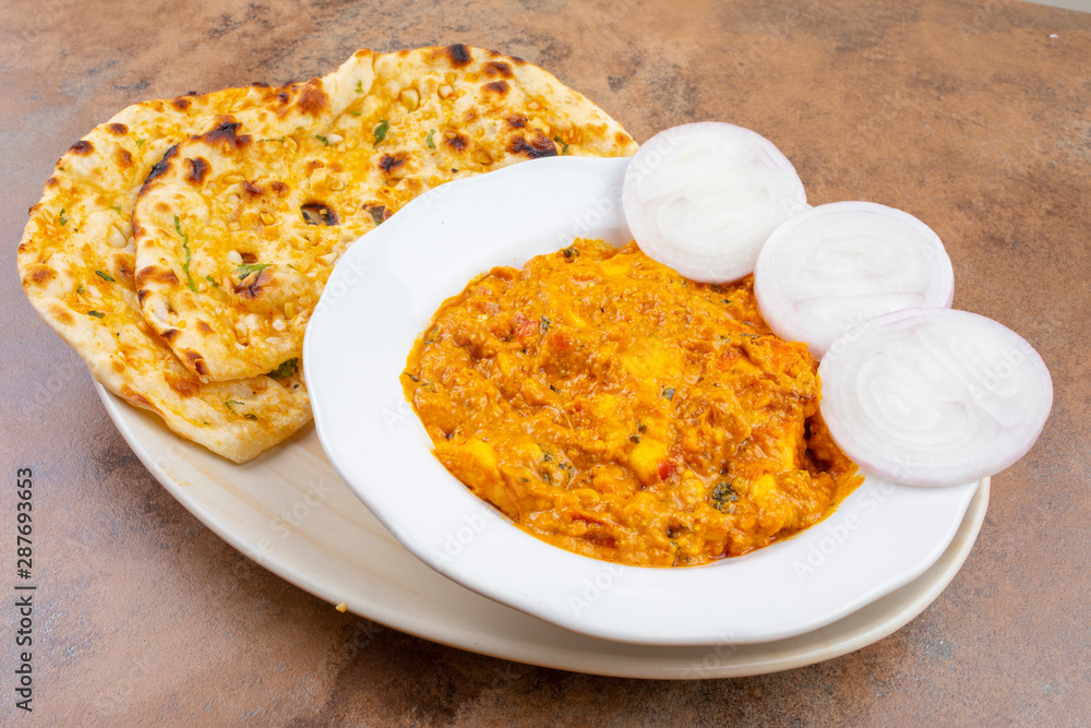 Indian Vegetarian Cuisine Special Sweet And Spicy Paneer Pasanda or Stuffed Paneer Curry, Delicacy Consisting of Stuffed Paneer with Rich Creamy Gravy Served With Garlic Naan on Vintage Background Indian Vegetarian Cuisine Special Sweet And Spicy Paneer Pasanda or Stuffed Paneer Curry, Delicacy Consisting of Stuffed Paneer with Rich Creamy Gravy Served With Garlic Naan on Vintage Background