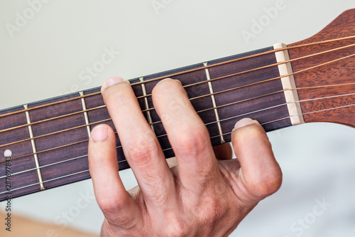 playing acoustic guitar with hand.