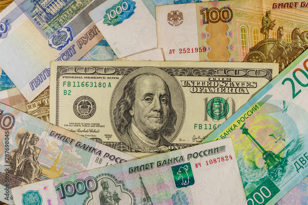 One hundred dollar bill on a background of russian rubles banknotes